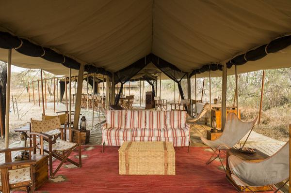 Spacious luxury tented lounge area at Serengeti Safari Camp with traditional decor.